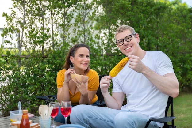 Happy family having barbecue bbq party with red wine in outdoor backyard garden of house with happy