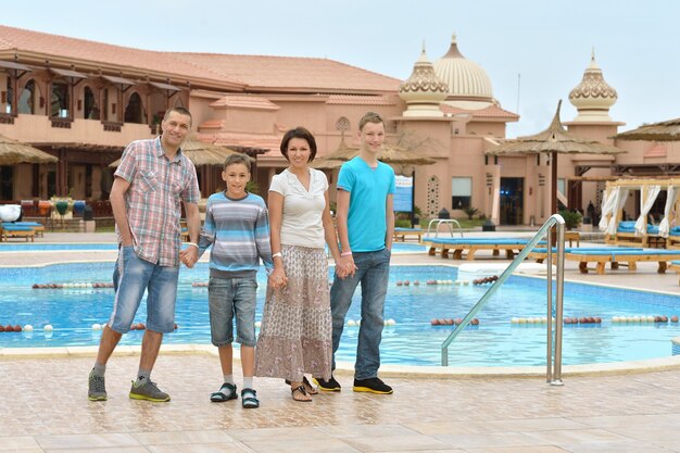 Happy family having fun at tropical resort near pool.