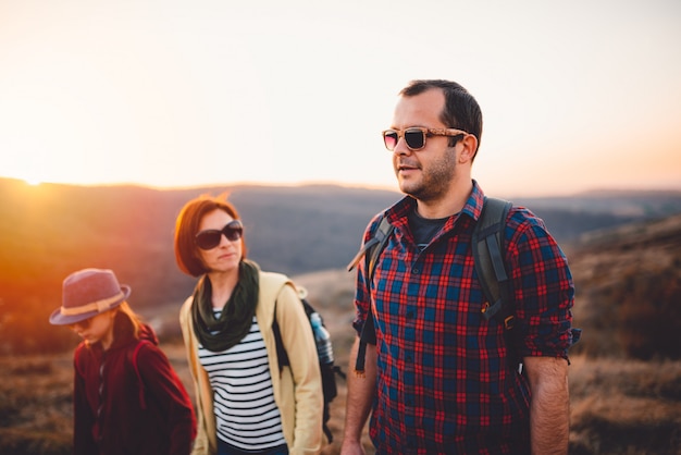 Happy family hiking on a dirt road during sunset