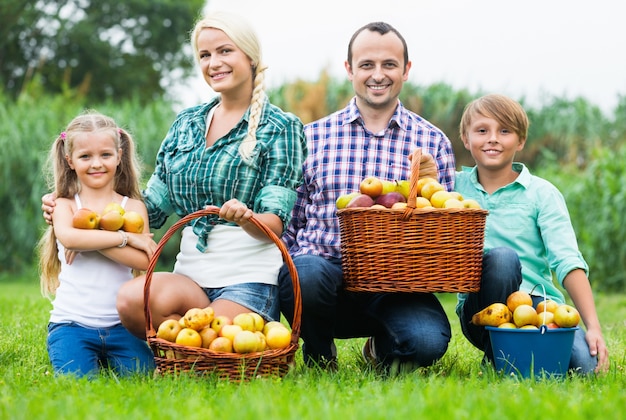 Happy family holding a basket with apples 