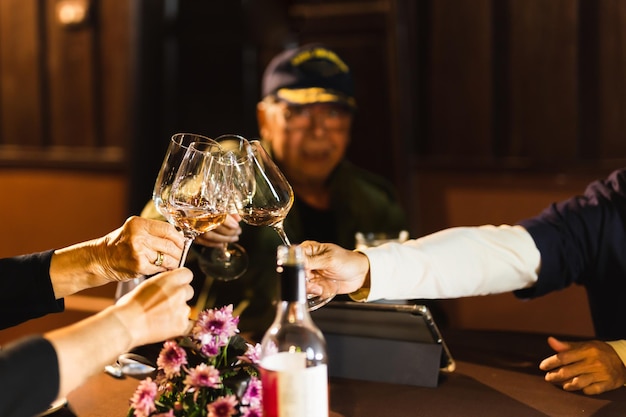 Happy family holding wine glasses toasting at dinner table