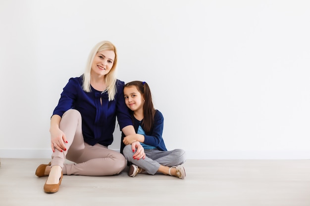 Happy family at home. Smiling woman and her little daughter have fun at home