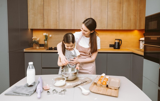 Happy family in the kitchen mother and daughter prepare dough bake cookies Easter cake