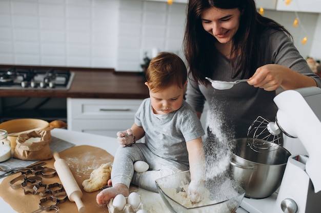 Happy family in the kitchen. mother and son preparing the dough, bake cookies