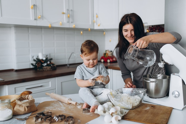 Happy family in the kitchen. mother and son preparing the dough, bake cookies