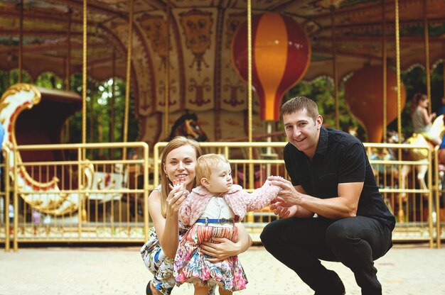 Happy family lifestyle and holiday. Mother, father, little girl sitting, walking in city, park