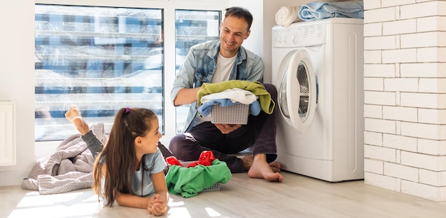 Happy Family loading clothes into washing machine in home