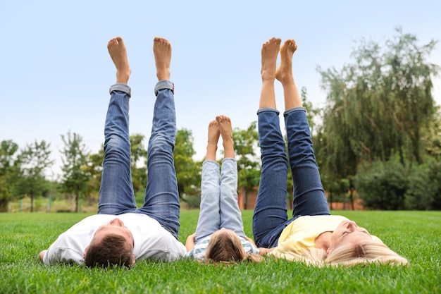 Happy family lying on green grass in park