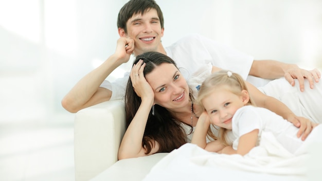 Happy family lying on the sofa on Sunday.photo with copy space