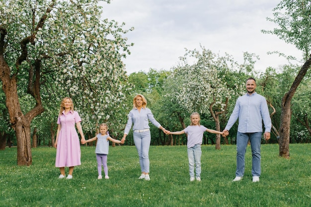 Happy family mom dad grandma and daughters walking in the park in the spring