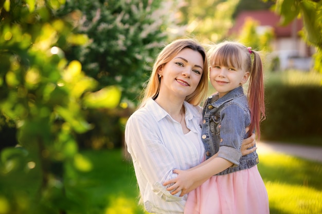 Happy family, mom and daughter in the summer park