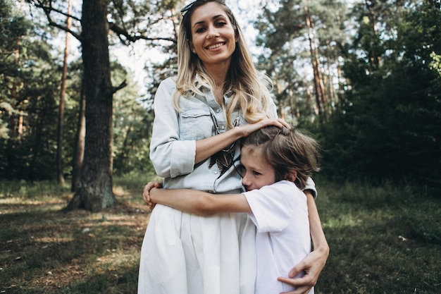 Happy family moments with kids sons in a forest