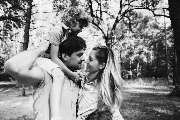 Happy family moments with kids sons in a forest