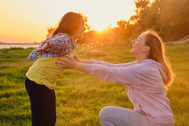 Happy family mother and child daughter in nature Park in summer on green grass