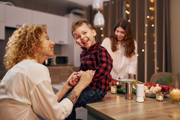 Happy family of mother daughter and son is on the kitchen at evening time