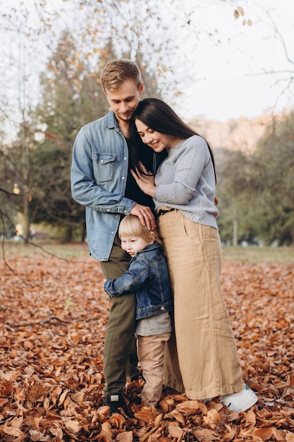 Happy family mother father and baby on autumn walk in the park