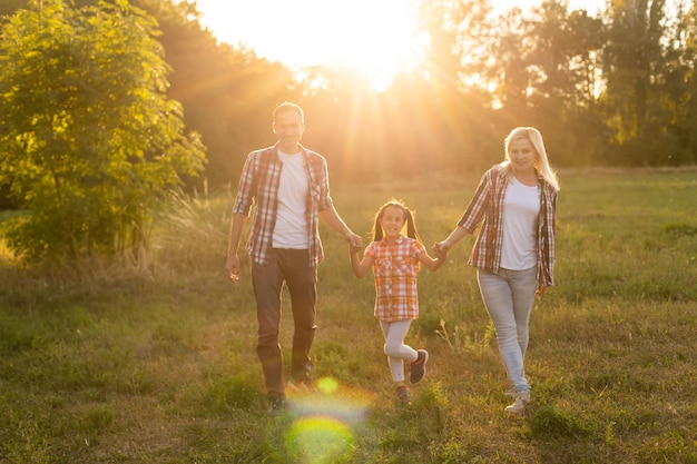 Happy family: mother father and child daughter on nature on sunset