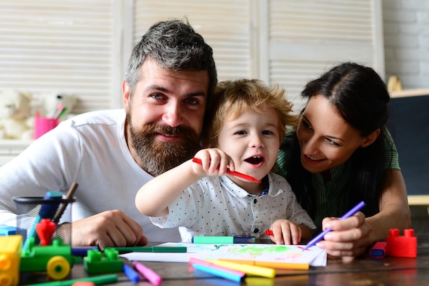 Happy family mother father and child drawing Happy family with children on weekend Young parents and their child are very happy at home Kids early arts and crafts education drawing