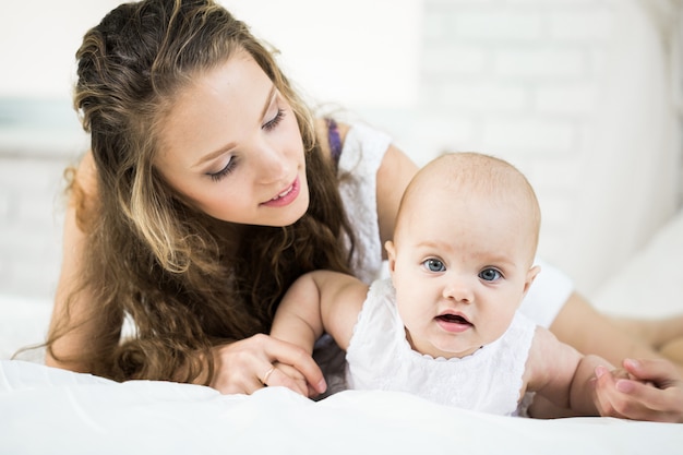 Happy family. mother playing with her baby in the bedroom.