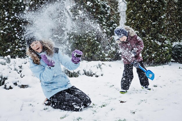 Happy family mother and son having fun outdoors in winter snowy nature background mom and kid