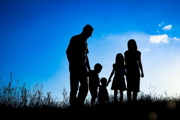 Happy family outdoors in the park silhouette