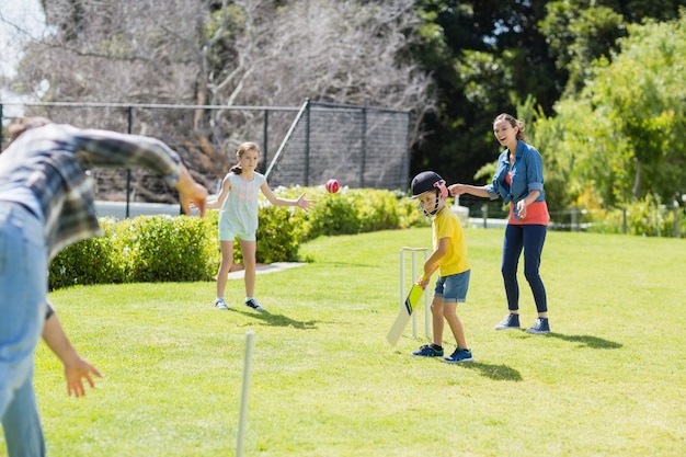 Happy family playing cricket together