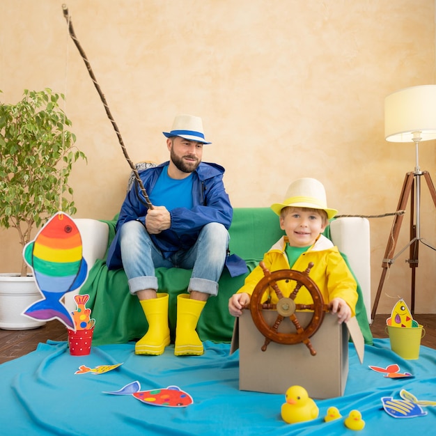 Happy family playing Dad and son enjoying a fishing trip Father and child having fun Man and kid at home Summer vacation and Fathers day concept