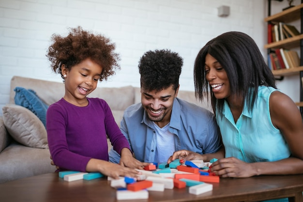 Happy family playing jenga together at home