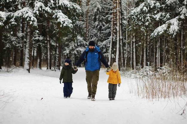 Happy family playing and laughing in winter outdoors in the snow. City park winter day.