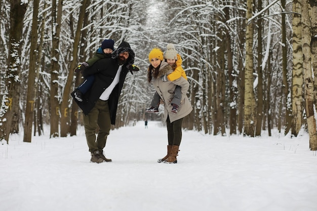 Photo happy family playing and laughing in winter outdoors in the snow. city park winter day.