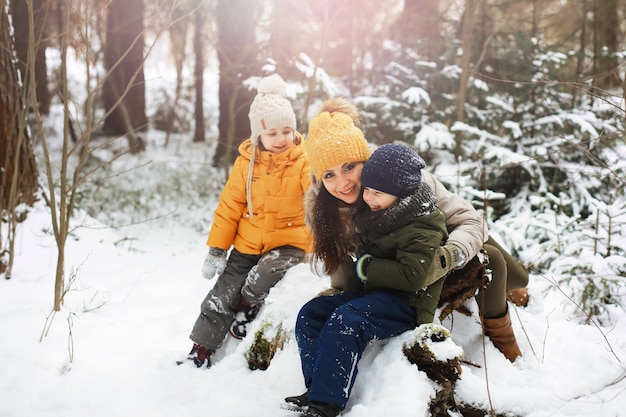 Happy family playing and laughing in winter outdoors in the snow. City park winter day.