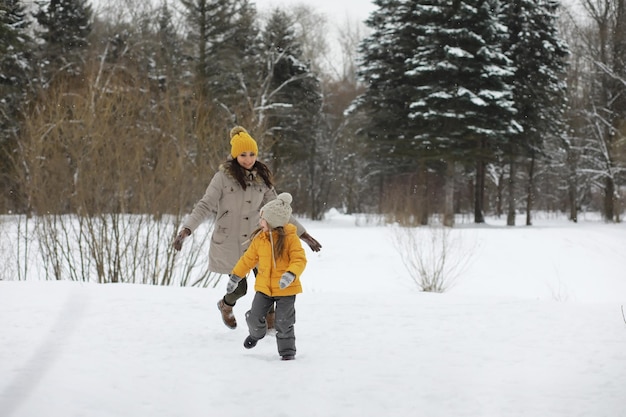 Happy family playing and laughing in winter outdoors in the snow. City park winter day.