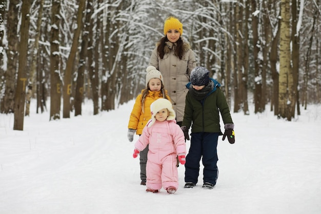 Happy family playing and laughing in winter outdoors in the snow. City park winter day.