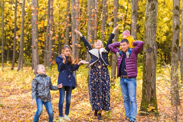 happy family playing with autumn leaves in park