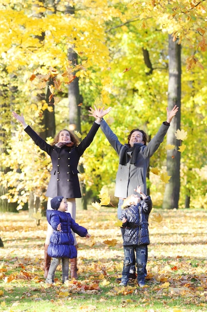 Happy family playing with autumn leaves