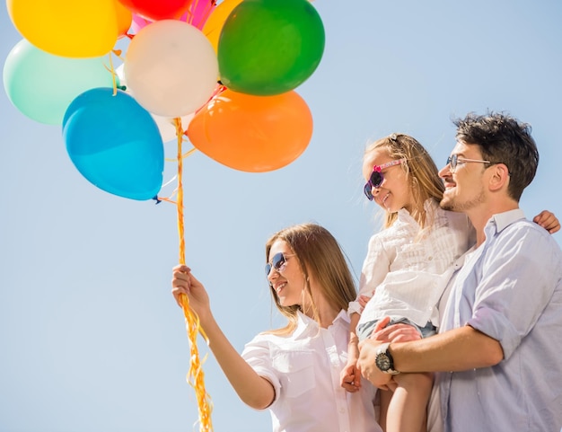 Photo happy family playing with balloons at the day time friendly family concept sky background