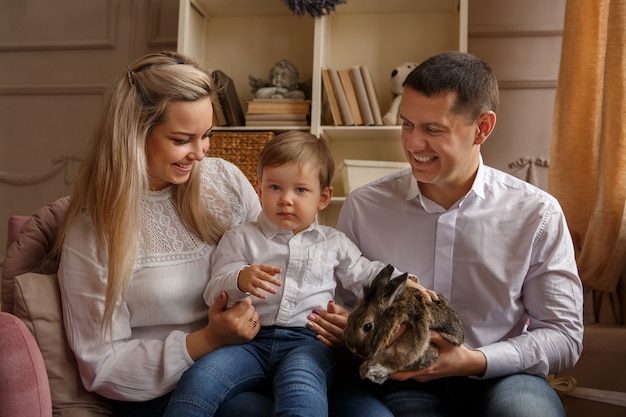 Happy family playing with Easter bunny and celebrating Easter day