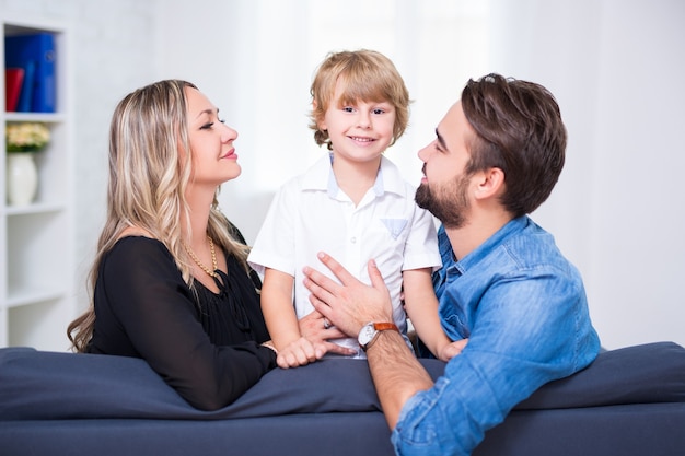 Happy family portrait - young couple and little son at home