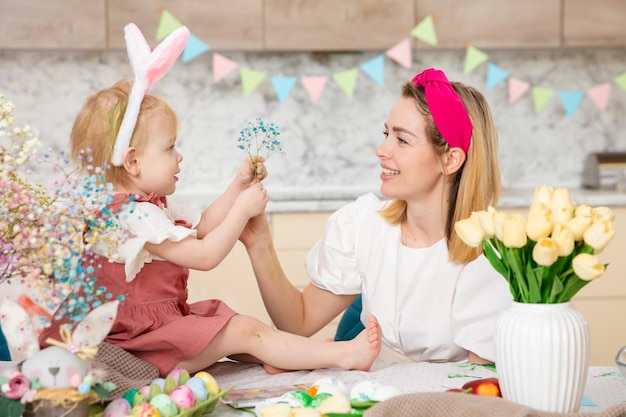 Happy Family preparing for Easter Cute girl plaing with mother Home activity Concept of unity and love Mom and daughter