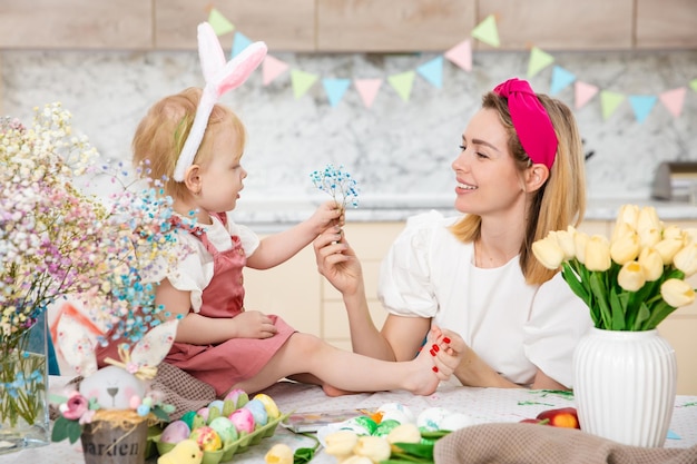 Happy Family preparing for Easter Cute girl with mother Home activity Concept of unity and love Mom and daughter