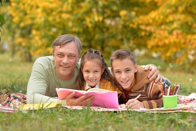 Happy Family resting in park with  book