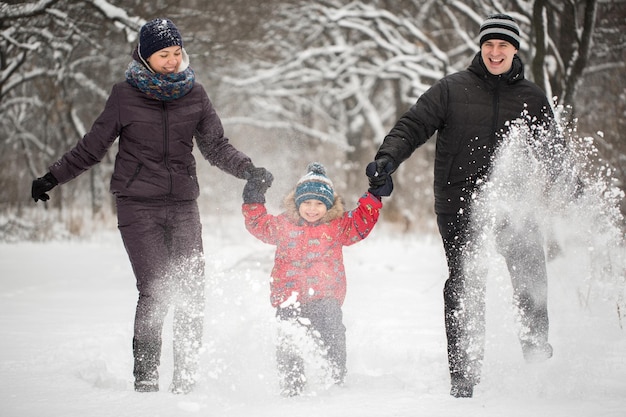 Happy family running on snow in winter