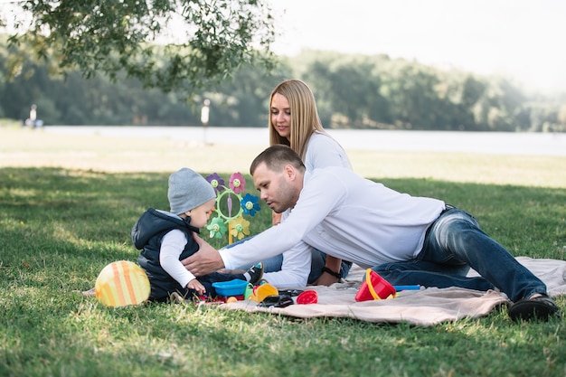 Happy family sitting on the grass in the Park on a spring day