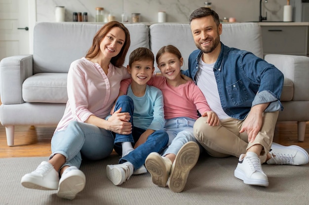 Happy family sitting together on floor at home