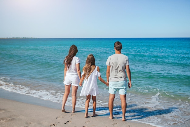 Happy family of three on the beach during summer vacation