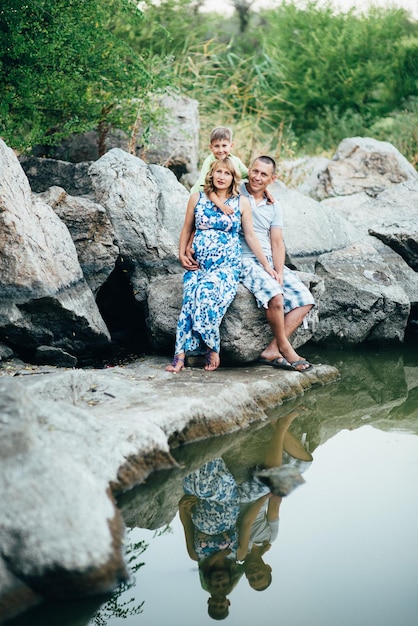 Happy family three dad mom and son walk in nature