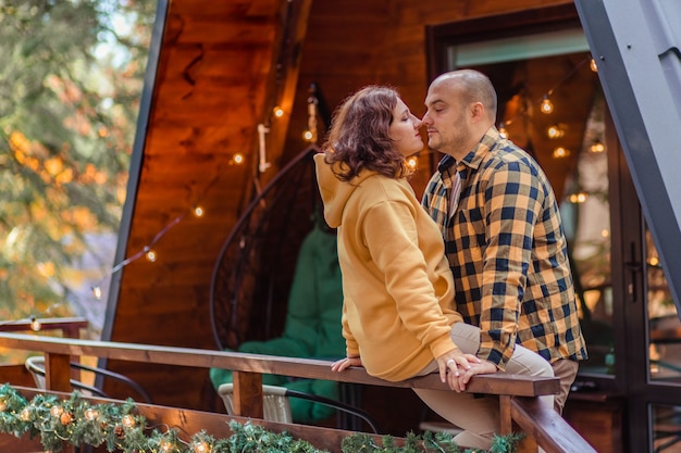 Happy family of travelers in the forest in the mountains near the wooden chalet house