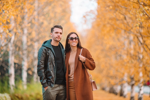 Happy family walking in autumn park on sunny fall day