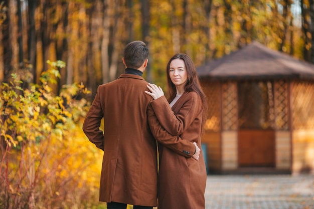 Happy family walking in autumn park on sunny fall day