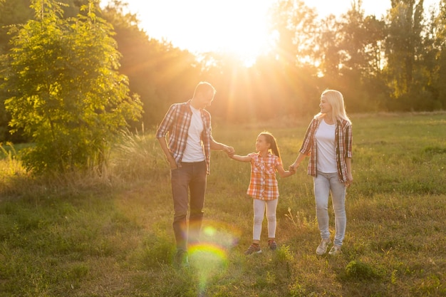 Happy family walking in field and looking at sunset